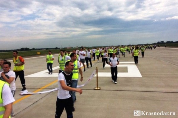 Сотрудники аэропорта бегают по взлетной полосе